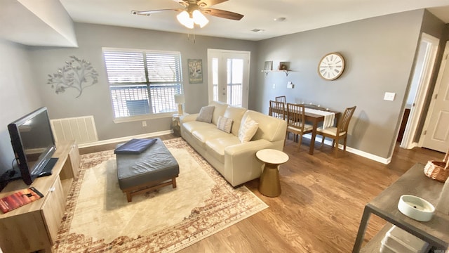 living room with a ceiling fan, wood finished floors, visible vents, and baseboards