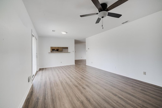 unfurnished living room with visible vents, ceiling fan, baseboards, and wood finished floors