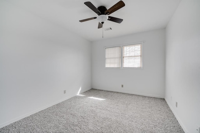 empty room with carpet floors, visible vents, ceiling fan, and baseboards