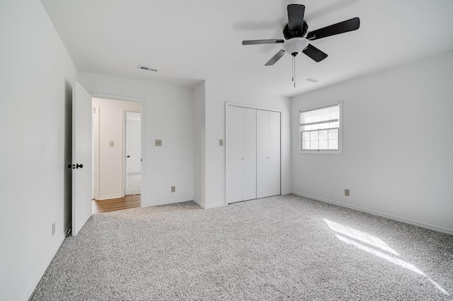 unfurnished bedroom featuring a closet, visible vents, baseboards, and carpet flooring