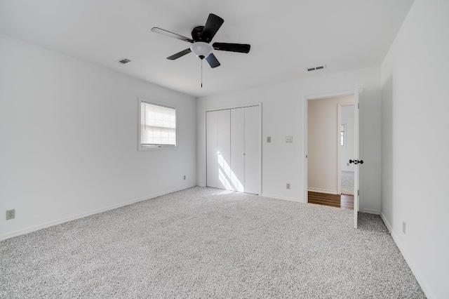 unfurnished bedroom featuring carpet floors, baseboards, visible vents, and a closet