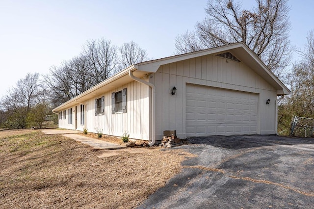 view of property exterior with a garage and aphalt driveway