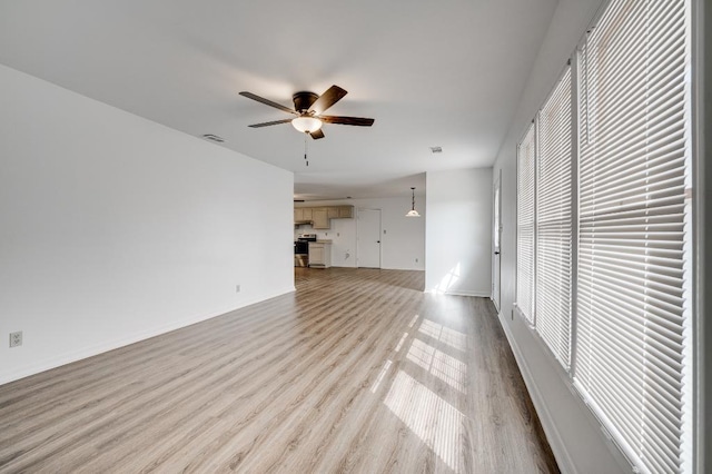 unfurnished living room featuring ceiling fan, light wood-type flooring, visible vents, and baseboards