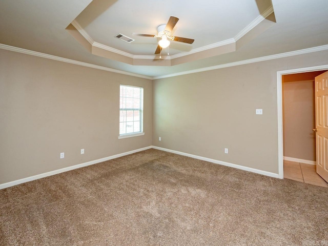 carpeted empty room featuring ornamental molding, a raised ceiling, and visible vents