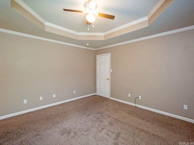 carpeted empty room with baseboards, a tray ceiling, a ceiling fan, and ornamental molding