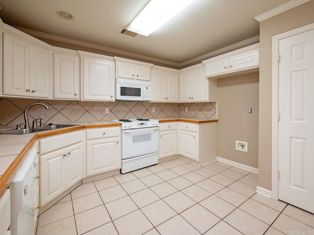 kitchen featuring light tile patterned floors, white appliances, a sink, visible vents, and crown molding