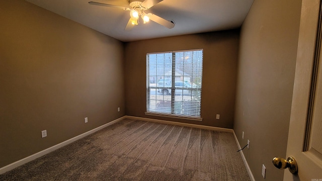 spare room featuring a ceiling fan, dark carpet, and baseboards