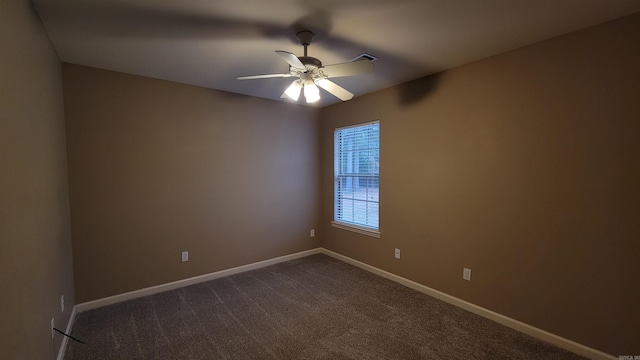 unfurnished room featuring ceiling fan, dark colored carpet, and baseboards