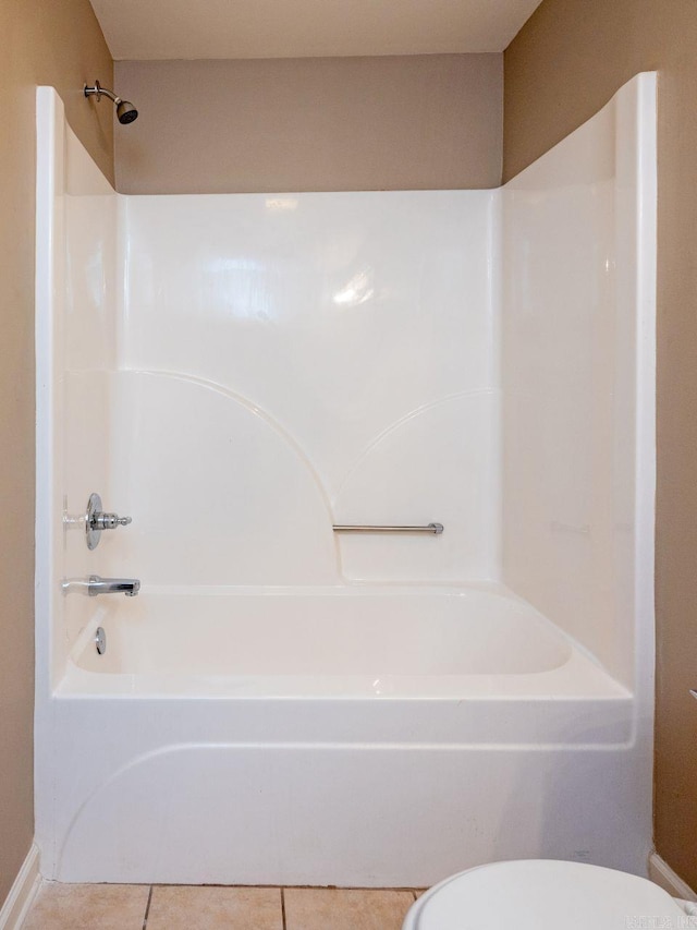 full bath with shower / tub combination, toilet, and tile patterned floors