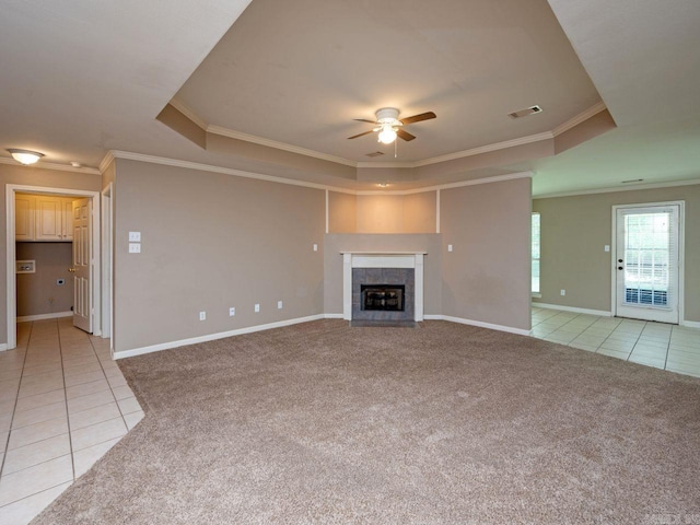 unfurnished living room with a raised ceiling, light colored carpet, visible vents, and light tile patterned floors