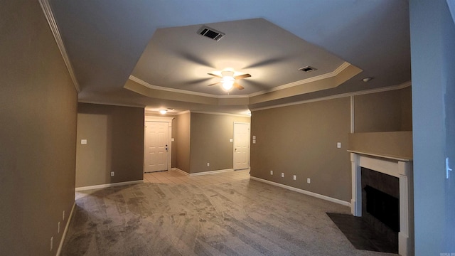 unfurnished living room with a fireplace with flush hearth, light colored carpet, a raised ceiling, and visible vents