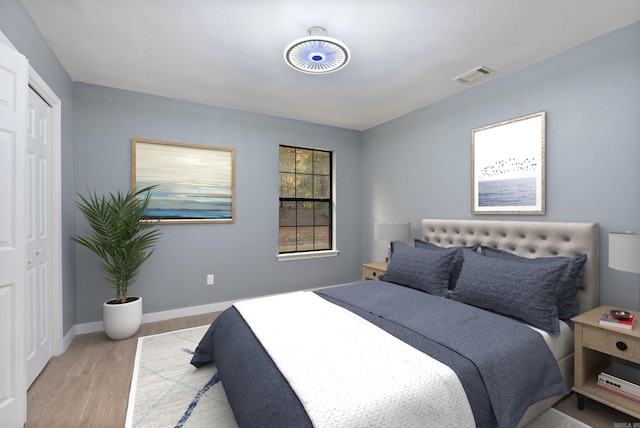 bedroom featuring baseboards, visible vents, and light wood-style floors