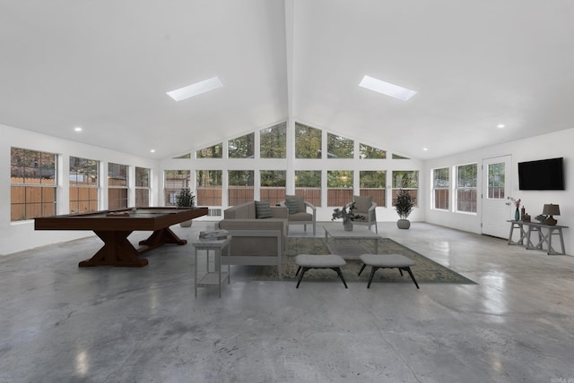 unfurnished living room with finished concrete floors, a skylight, and high vaulted ceiling