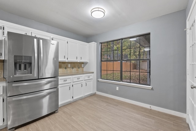 kitchen featuring light wood-style flooring, decorative backsplash, white cabinetry, and stainless steel fridge with ice dispenser