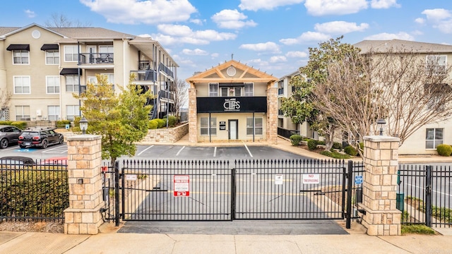 exterior space featuring uncovered parking, a gate, and fence