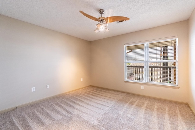 spare room with ceiling fan, a textured ceiling, carpet, and baseboards