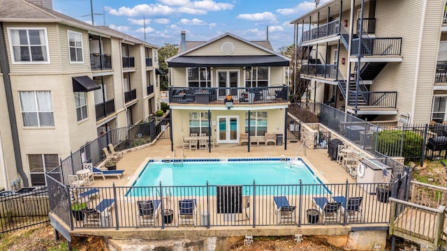 pool featuring french doors, grilling area, a patio area, and fence