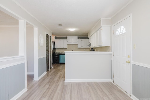 kitchen with visible vents, dishwashing machine, a peninsula, light wood-style floors, and white cabinets