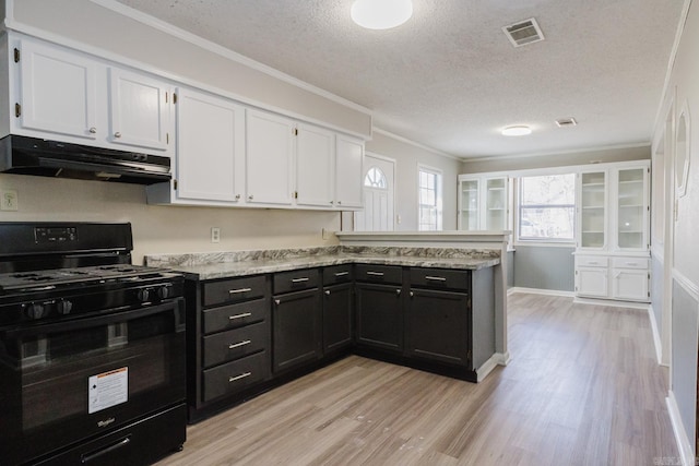 kitchen featuring under cabinet range hood, visible vents, black gas range, and white cabinetry