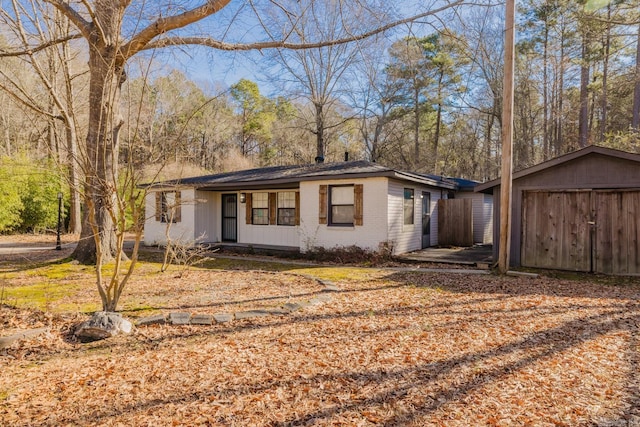 view of front of home featuring brick siding, a storage shed, and an outdoor structure