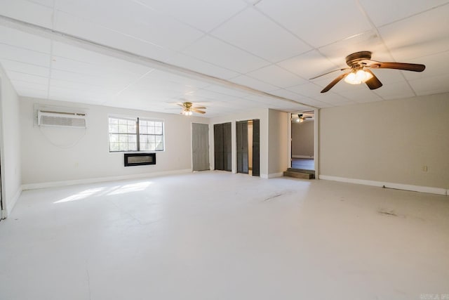 unfurnished living room with baseboards, finished concrete floors, and a wall mounted AC