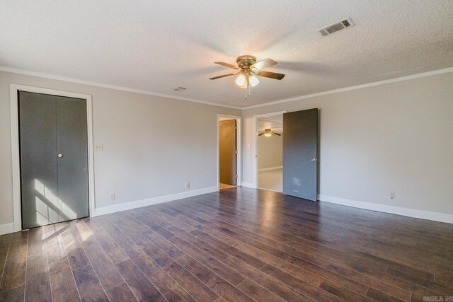 unfurnished room with visible vents, ornamental molding, a ceiling fan, a textured ceiling, and dark wood-style flooring