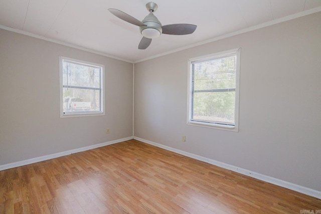 empty room featuring crown molding, baseboards, and light wood finished floors