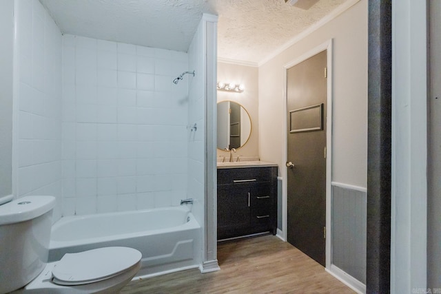 full bath with vanity, a textured ceiling, wood finished floors, shower / bath combination, and toilet