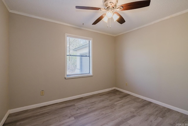 unfurnished room featuring a textured ceiling, wood finished floors, baseboards, and ornamental molding