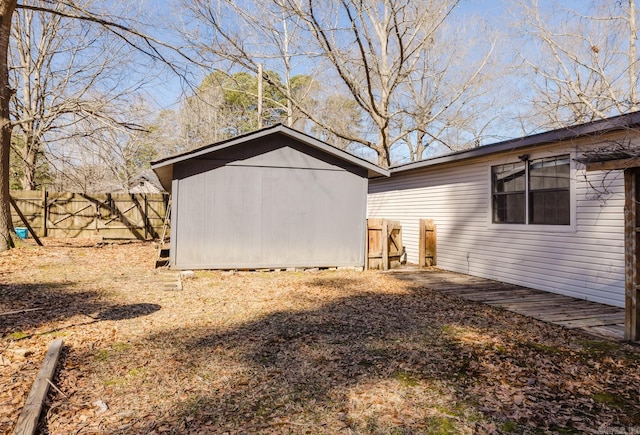 view of home's exterior featuring fence, an outdoor structure, and a shed