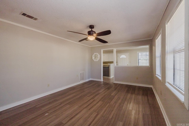 empty room with visible vents, wood finished floors, and crown molding