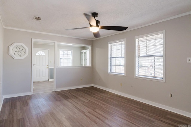 spare room featuring visible vents, plenty of natural light, and wood finished floors