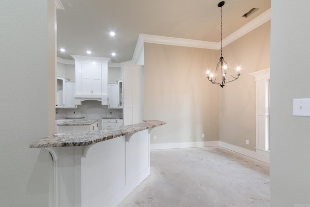 kitchen with visible vents, white cabinets, unfinished concrete floors, light stone counters, and a kitchen breakfast bar