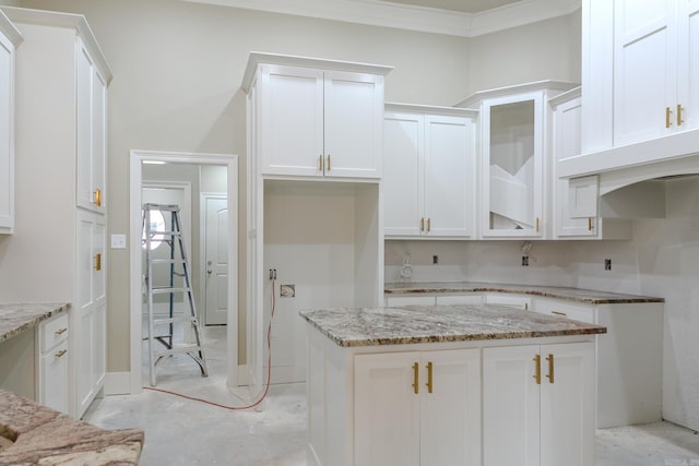 kitchen with glass insert cabinets, unfinished concrete floors, light stone counters, and white cabinets