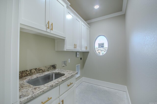 clothes washing area with hookup for a washing machine, cabinet space, ornamental molding, hookup for an electric dryer, and a sink