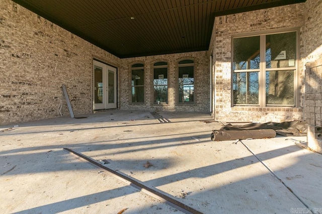 doorway to property with french doors, a patio area, and brick siding