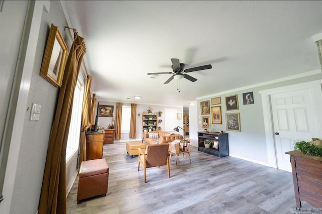 interior space featuring light wood-style floors, ceiling fan, a fireplace, and baseboards