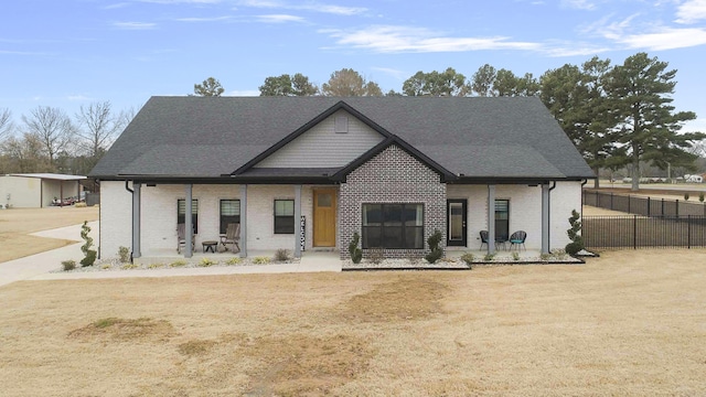 view of front of home featuring fence, a porch, and brick siding