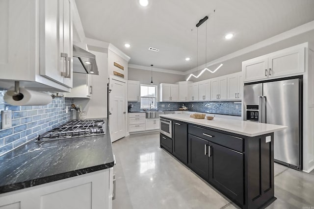 kitchen with dark cabinets, white cabinetry, appliances with stainless steel finishes, a center island, and decorative light fixtures