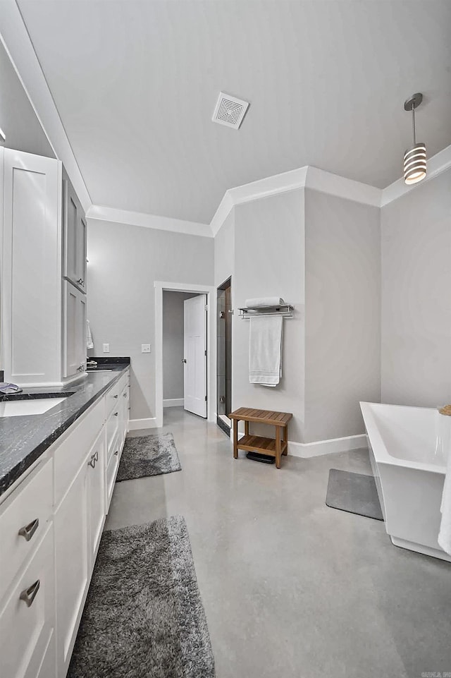 bathroom with concrete flooring, vanity, visible vents, baseboards, and a soaking tub