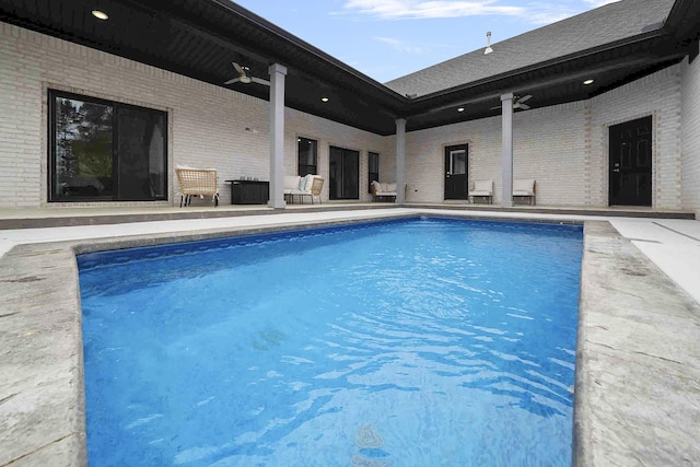 pool with a ceiling fan and a patio area