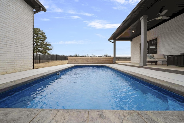 outdoor pool with a patio area and a fenced backyard