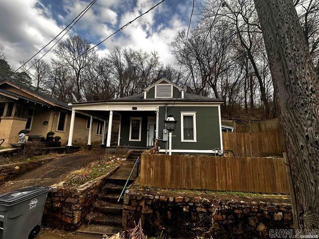 view of front of home with a porch and fence