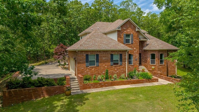 view of front of house featuring a front yard, concrete driveway, brick siding, and roof with shingles