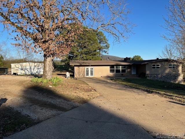 single story home featuring concrete driveway and french doors