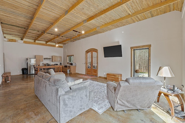 living room featuring arched walkways, concrete floors, a towering ceiling, wood ceiling, and beamed ceiling