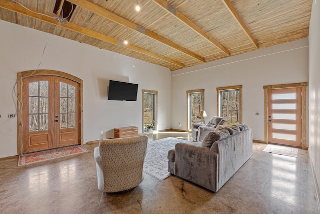 living area featuring arched walkways, french doors, beam ceiling, a towering ceiling, and wooden ceiling