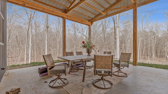 view of patio with a forest view and outdoor dining space