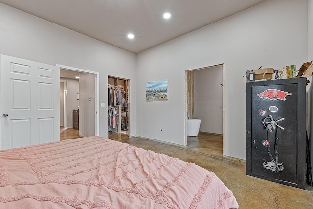 bedroom with concrete flooring, a walk in closet, a closet, and recessed lighting