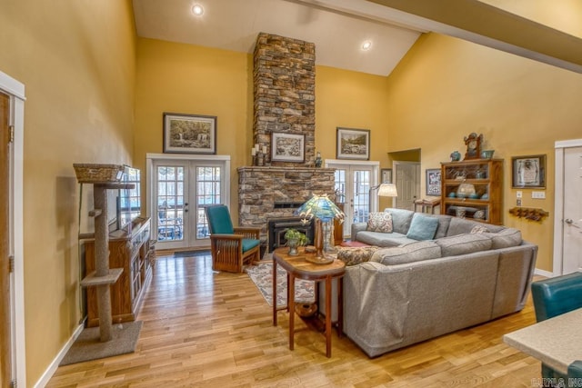living room with light wood finished floors, high vaulted ceiling, and french doors